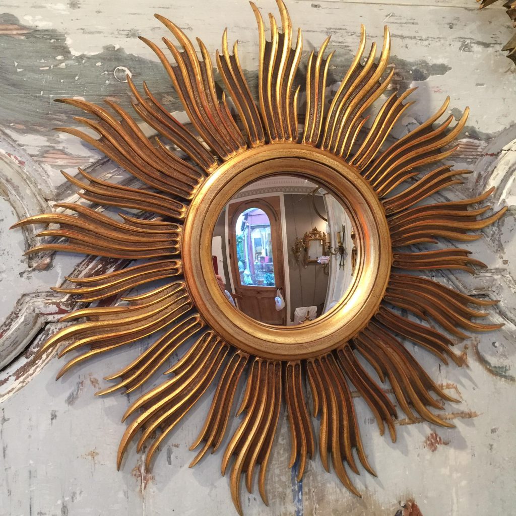 Miroir soleil en bois doré.